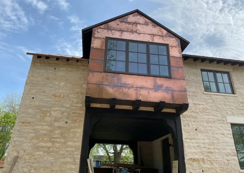 Copper metal panel facade on a stone building for Skylight Installation in Blair