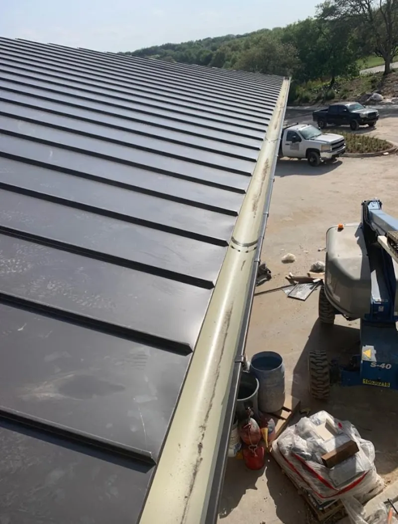 Standing seam panel and gutter detail on a metal roofing jobsite in Blair